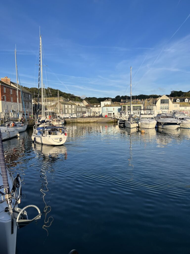 Serene Padstow marina on a clear day with moored sailboats reflecting on the calm waters, highlighting things to do in Padstow, Cornwall